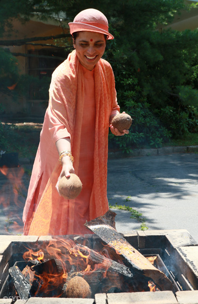 Gurumayi offering coconuts to fire